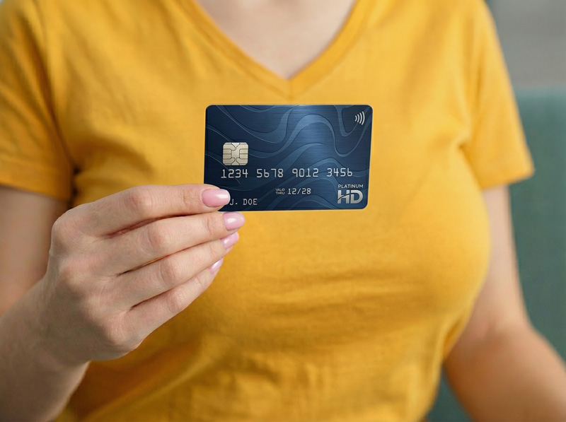 Woman-holding-credit-card-indoors-closeup