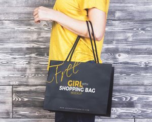 Girl-With-Shopping-Bag-MockUp-Freebie-on-Antique-Wooden-Background